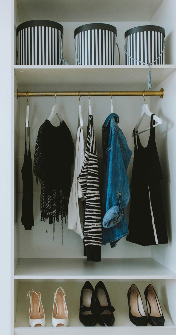 An organized closet with clothes and shoes lined up